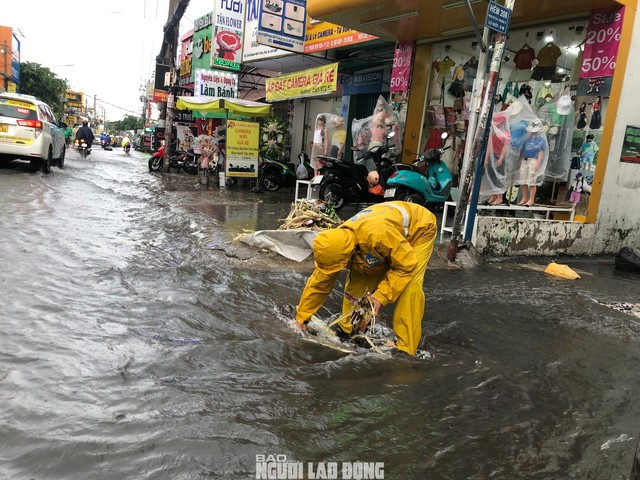 Công nhân Công ty Thoát nước đô thị TP HCM nhặt rác tại các miệng cống