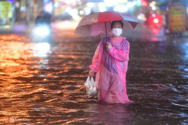 Không dám đi xe vì sợ nguy hiểm, chị Nguyễn Thị Minh, nhà trên đường Nguyễn Duy Trinh, lội nước đi mua đồ ăn.