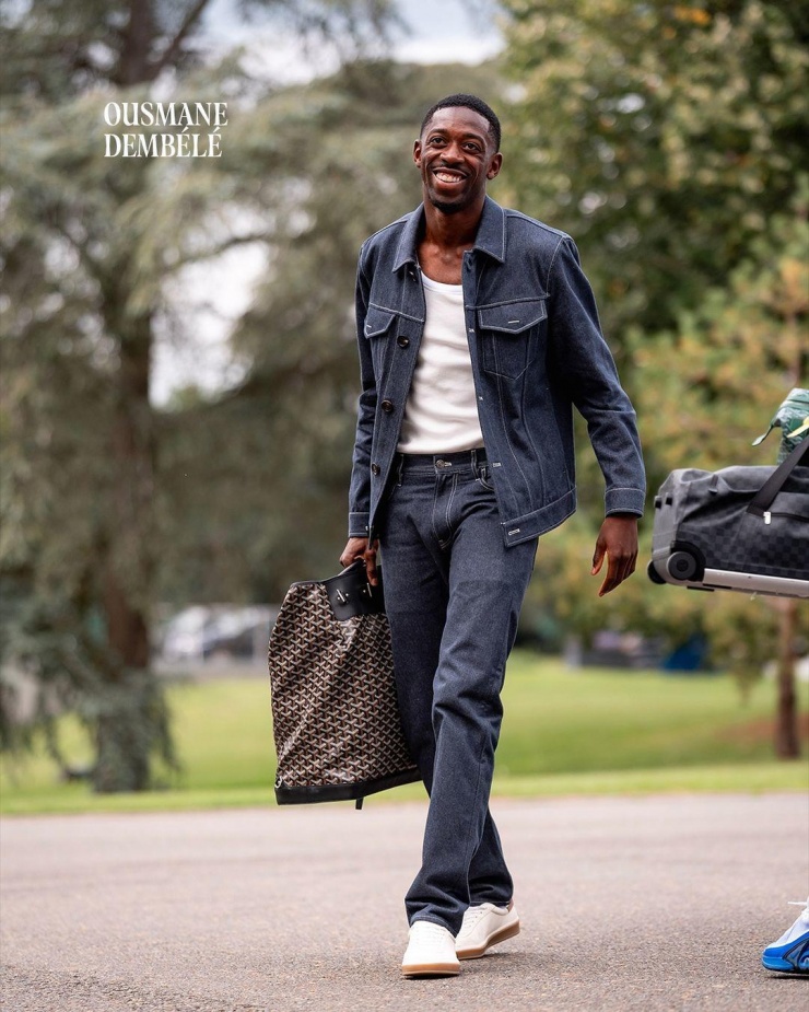 
Tiền đạo cánh Ousmane Dembele (PSG) phối áo ba lỗ với set denim xanh, giày thể thao và túi du lịch Goyard.