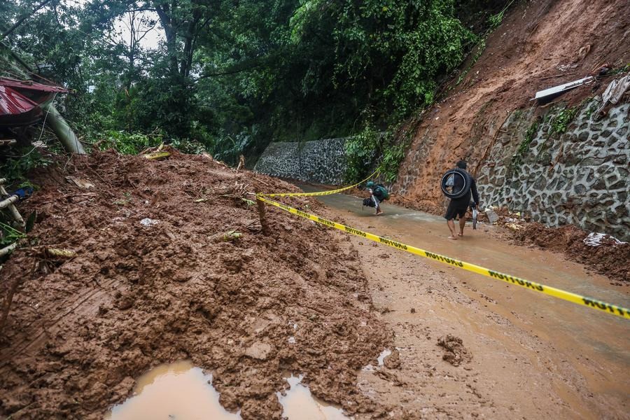 Người dân đi ngang qua một khu vực sạt lở đất do mưa lớn ở tỉnh Rizal, Philippines ngày 2/9/2024. Ảnh: Xinhua