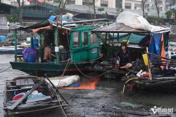 Trong lúc này, một vài người vẫn chọn cách ở lại thuyền để giữ tài sản. "Từ sáng tới giờ tôi chưa ăn gì", người đàn ông trong ảnh nói lớn.