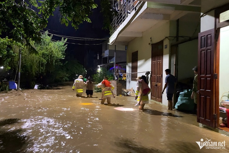 Lực lượng công an cõng cháu nhỏ sơ tán khỏi điểm ngập lụt ở TP Cao Bằng.