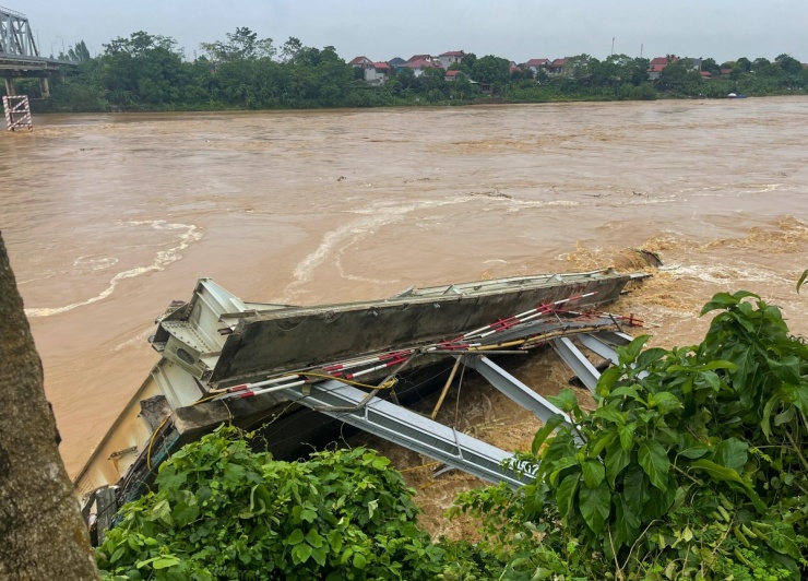 Một phần nhịp cầu bị sập nằm ven bờ sông Hồng phía huyện Tam Nông.