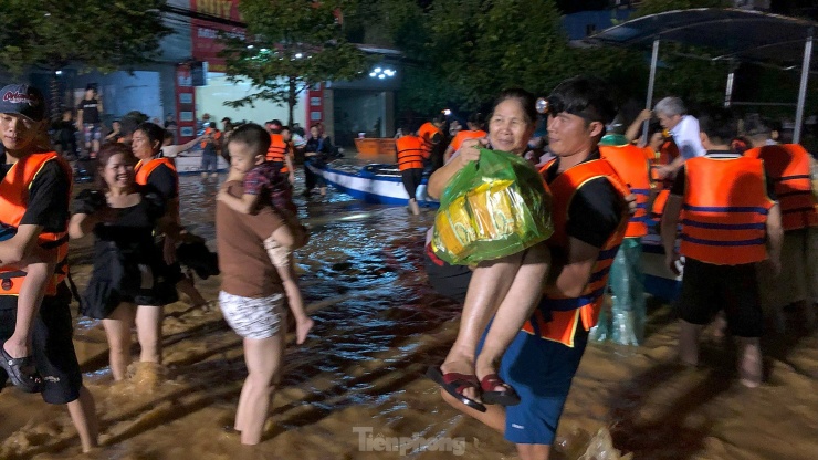 Nhiều người dân được cứu trợ ra khỏi khu vực bị ảnh hưởng lũ lụt lúc nửa đêm. Ảnh: Hoàng Mạnh Thắng