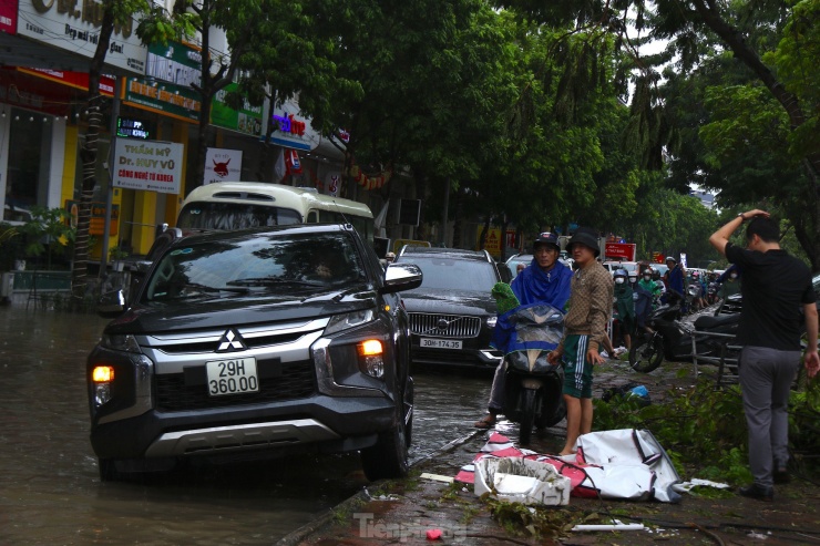 Các phương tiện tìm cách thoát thân bằng cách đi ngược chiều, trèo lên vỉa hè... để tránh chỗ ngập.