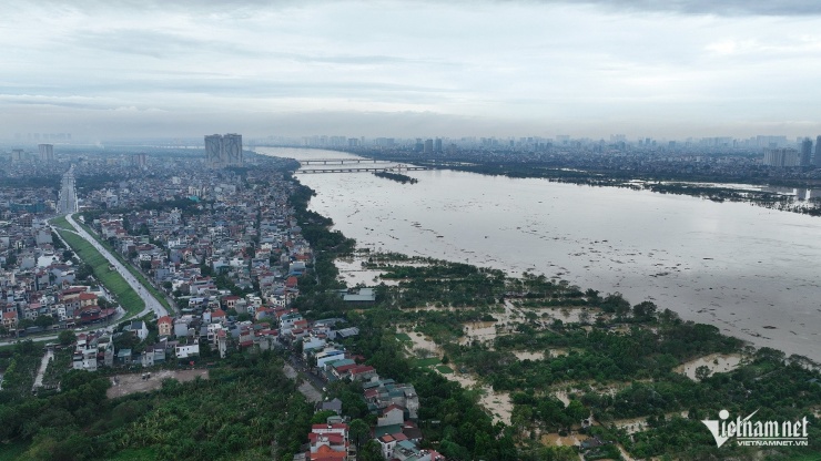  17h ngày 10/9, bãi giữa sông Hồng chỉ còn lại một khóm cây nhú lên. Các mảng xanh ngày nào   bị chìm nghỉm dưới dòng nước lũ. Ảnh: Hoàng Hà  