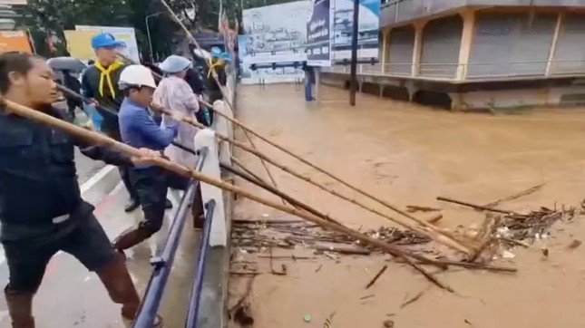 Người dân Thái Lan vớt rác dưới cầu ở tỉnh Chiang Rai, ngày 11/9. (Ảnh: Reuters)