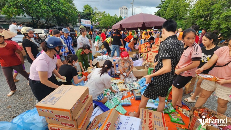 Những thùng hàng cứu trợ được tập kết để lực lượng chức năng phân loại và chuyển vào trong vùng ngập cho người dân bị cô lập. Ảnh: Đoàn Bổng 