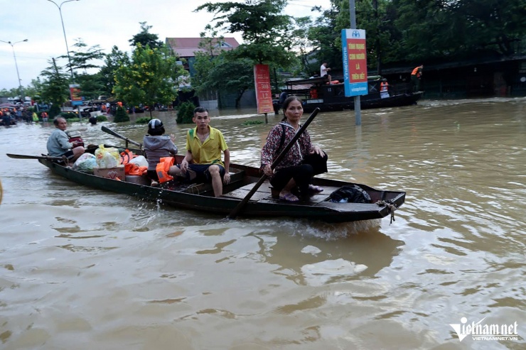 Xuồng máy chở người dân rời vùng ngập. Ảnh: Lê Anh Dũng 