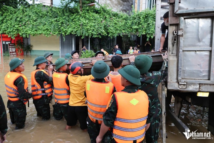 Bộ đội hạ thuyền máy để đẩy nhanh quá trình tiếp tế cho người dân vùng ngập. Ảnh: Lê Anh Dũng 