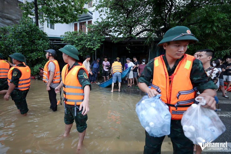 Từng gói hàng cứu trợ được lực lượng chức năng chuyển lên xuồng máy. Ảnh: Lê Anh Dũng 