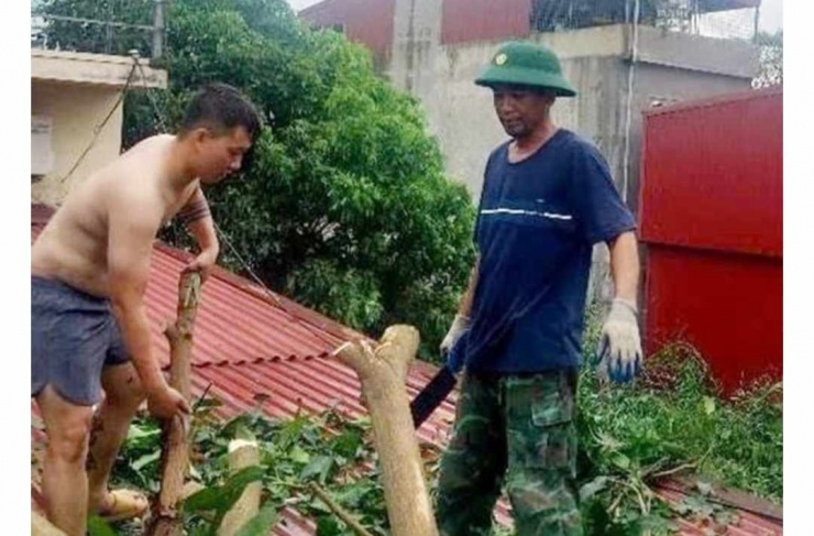 Thiếu tá Hưng cùng người dân cắt tỉa, dọn dẹp cây gãy đổ sau bão số 3 tại Hải Phòng. Ảnh: CTV