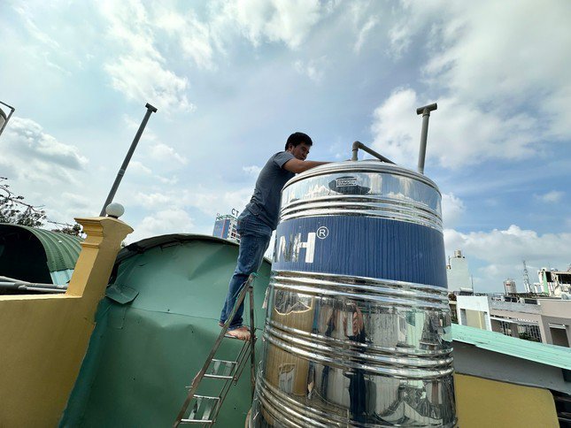 Ông Nguyễn Quốc Huy kiểm tra bồn nước trên sân thượng của gia đình (ảnh: Hữu Huy)