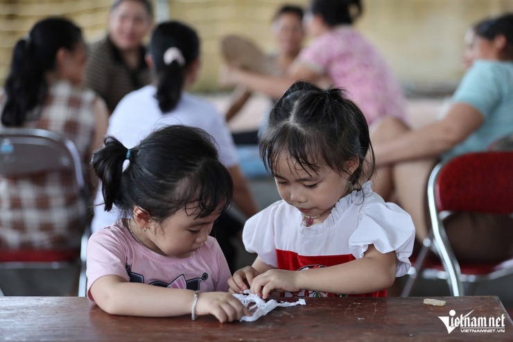 Người lớn, trẻ nhỏ đang tránh lũ tại nhà văn hoá thôn Tiên Phong. Ảnh: Lê Anh Dũng 