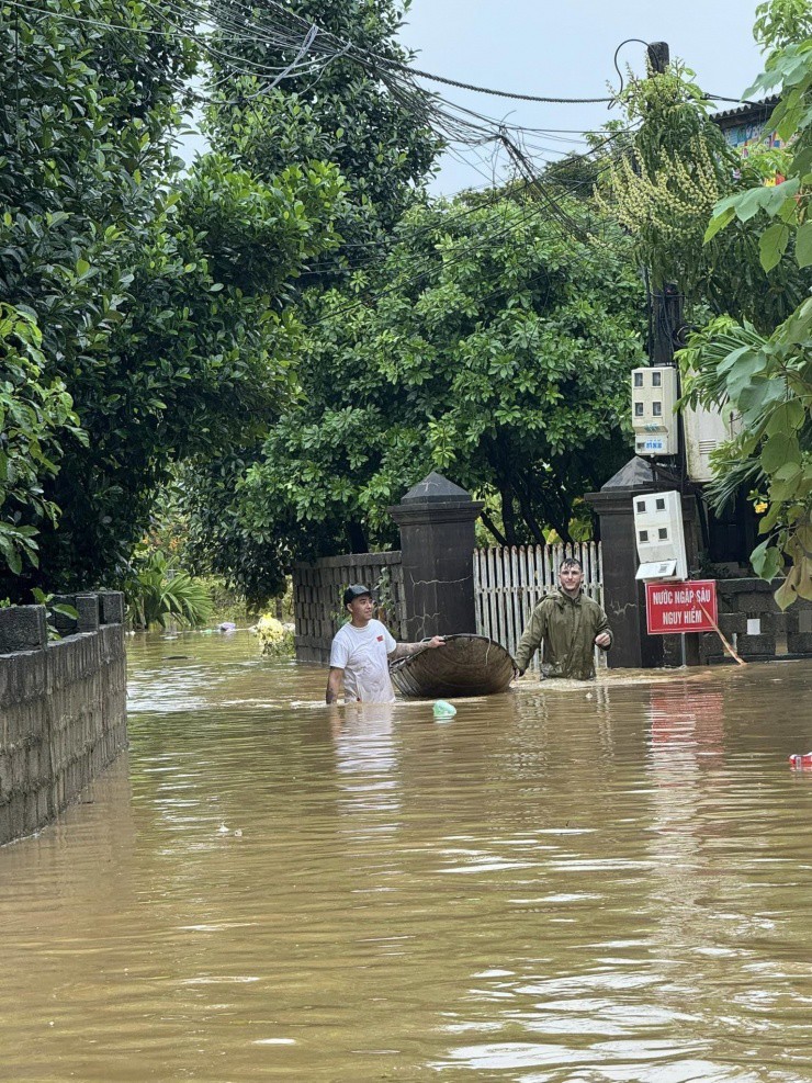 Chàng trai ngoại quốc không ngại lội nước lũ ở các điểm ngập sâu để vận chuyển đồ tiếp tế cho từng hộ dân bị ảnh hưởng bởi mưa lũ. Ảnh: Nathan Keer