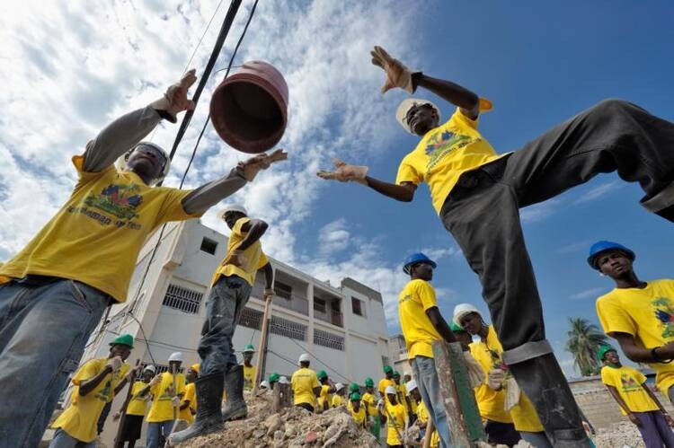 Người sống sót ở Haiti dọn dẹp đống đổ nát sau thảm họa động đất năm 2010. Ảnh: CNS