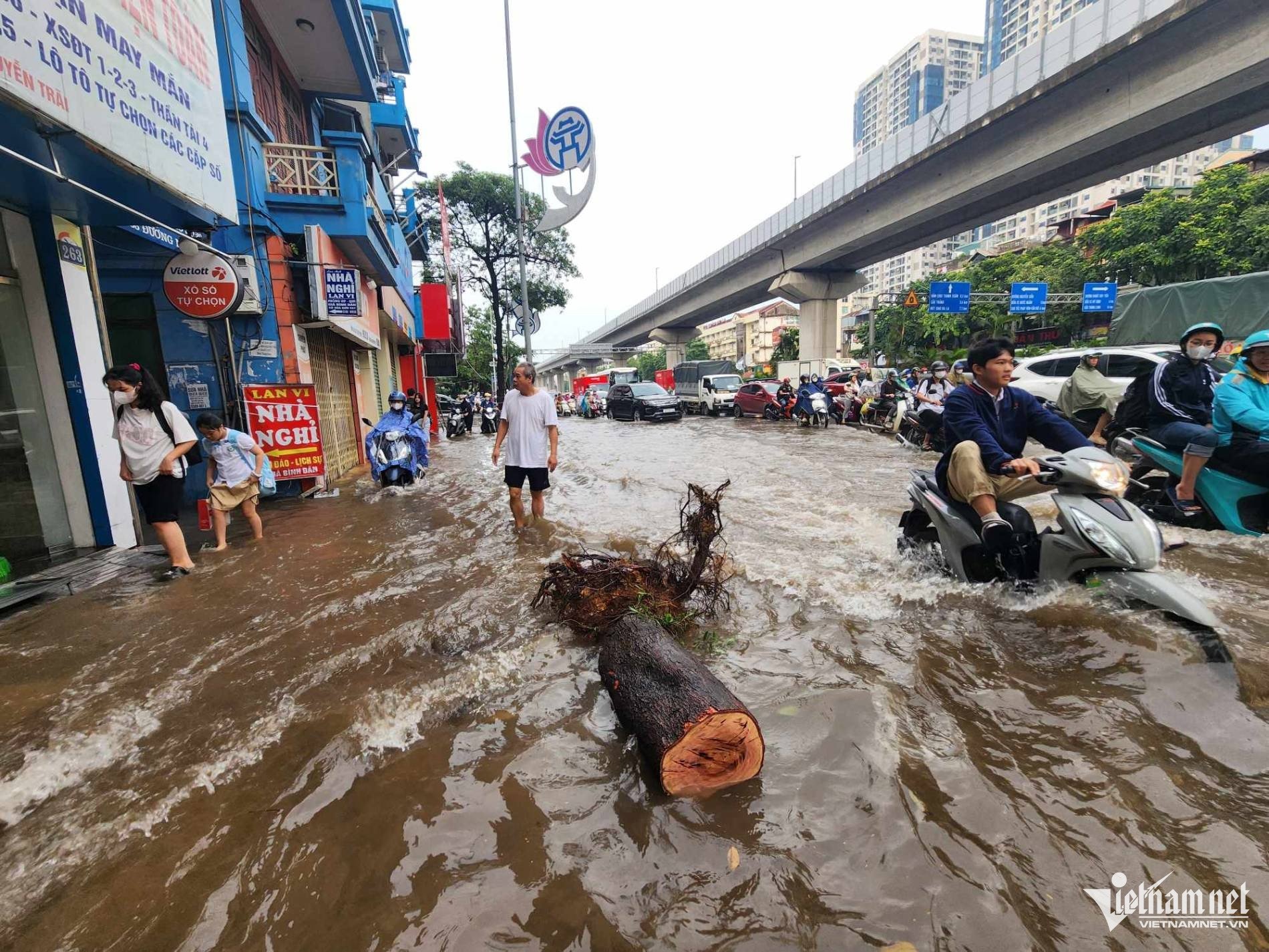 Học sinh men theo vỉa hè, lội bì bõm tới trường.