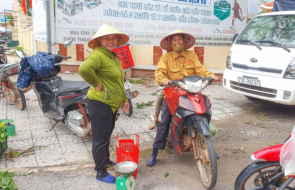 Nụ cười phấn khởi của hai người dân huyện Lệ Thủy sau khi nhanh chóng bán hết các giỏ nấm tràm hái được để kiếm thêm thu nhập. Ảnh: B.THIÊN