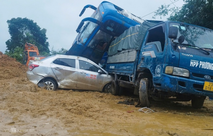 Ít nhất một xe khách giường nằm, hai ôtô 5 chỗ, hai xe tải đang lưu thông bị bùn đất xô về góc đường nằm đè lên nhau. Nhiều người bên trong xe phát cửa kính tháo chạy ra ngoài.