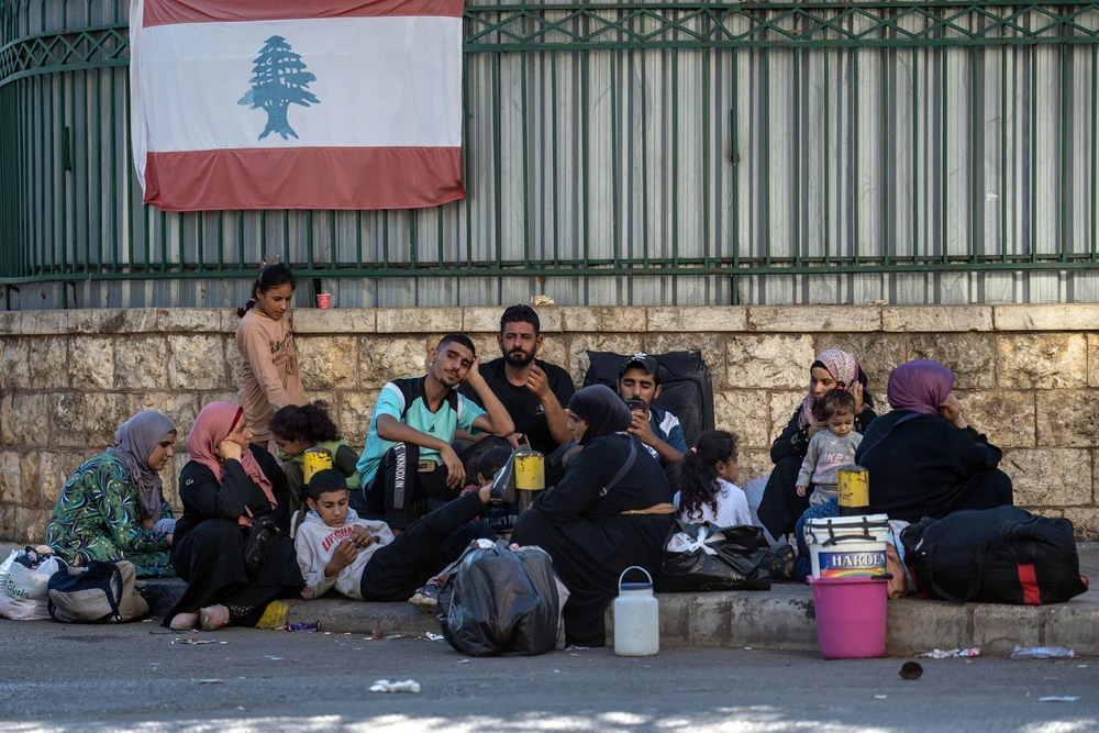 Người dân di tản, tránh các cuộc không kích của Israel đang ngồi bên đường ở Dahiyeh, Beirut (Lebanon). Ảnh: Carl Court