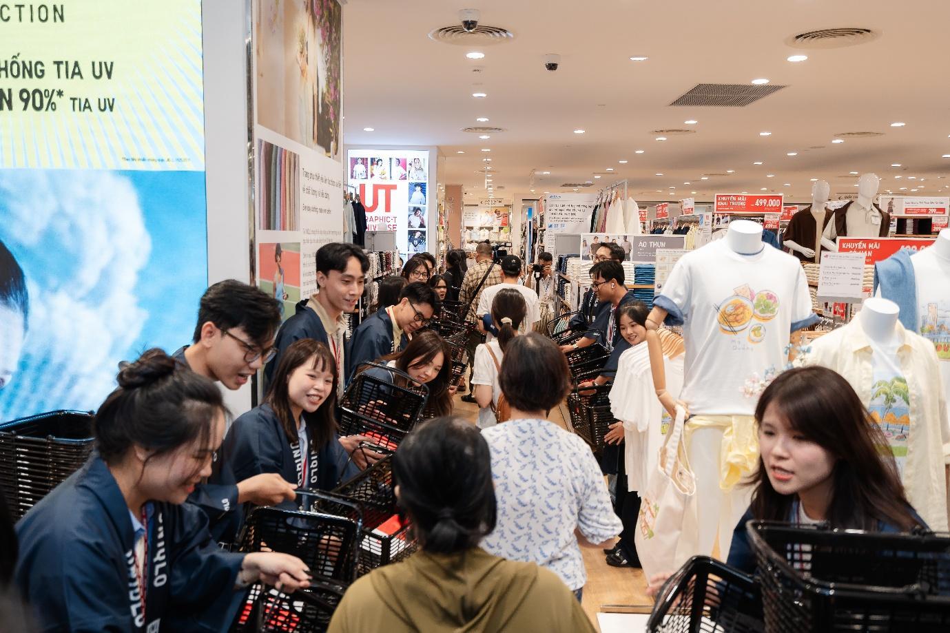 Nhân viên UNIQLO xếp hàng hai bên để chào đón những vị khách hàng đầu tiên đến tham quan, mua sắm.