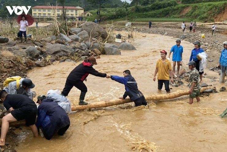 Người dân làm cầu tạm qua suối, giúp lưu thông tạm trên quốc lộ 32 cho người đi bộ.