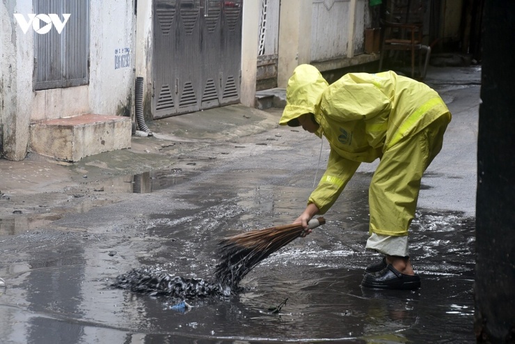 Công nhân quét lớp nước bùn đen mùi hôi nồng nặc