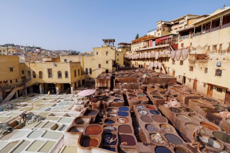 Bước qua cổng Bab Bou Jeloud được lát gạch xanh đặc trưng tại thành phố Fez (Morocco), du khách sẽ như được ngược dòng thời gian để trở về thời Trung cổ. Những trải nghiệm không thể bỏ qua tại thành phố này là mê cung với hàng ngàn con hẻm ở Fes el-Bali, khu thành cổ, hoặc những nhà hàng cung cấp món pastilla (bánh chim bồ câu), món súp hầm tagine đặc trưng và các loại trà truyền thống.