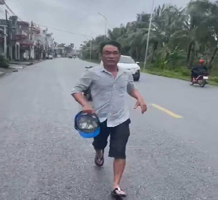 Người đàn ông hùng hổ cẩm mũ bảo hiểm chạy lại đánh tài xế ô tô. (Ảnh cắt từ clip)