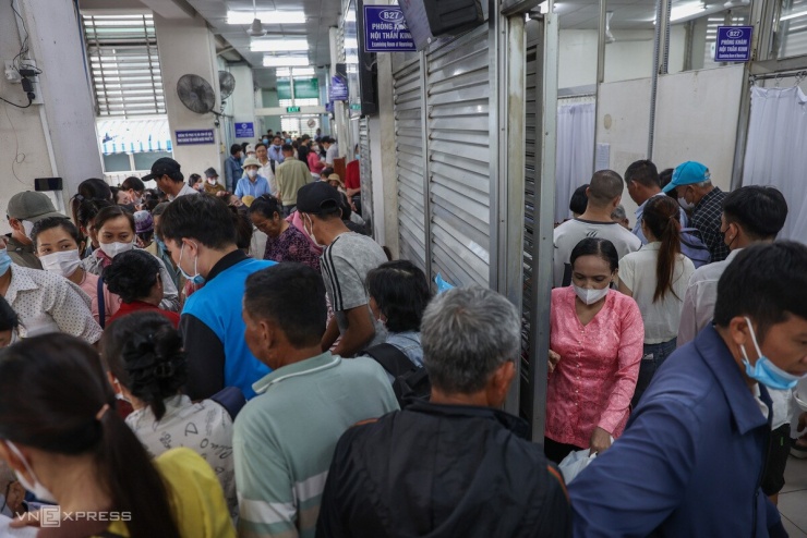 Xong khâu tiếp nhận, người bệnh chuyển sang phòng đóng tiền khám và tiếp tục ngồi chờ kín các hàng ghế. Bệnh viện để sẵn ghế ngồi chờ nhưng bệnh nhân đông, hết ghế, nhiều người phải đứng.