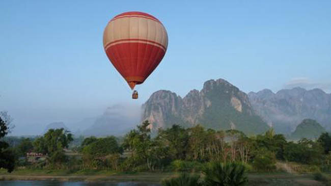 Vang Vieng: Địa điểm du lịch hấp dẫn ở Lào này sẽ làm bạn bị bỏ bùa mê. Thị trấn được bao bọc bởi những dãy núi đá vôi và cánh rừng bạt ngàn nên khí hậu mát mẻ quanh năm. Đến Vang Vieng, bạn có thể tham gia nhiều hoạt động hấp dẫn: Nghỉ ngơi trong lều cỏ trên mặt nước, chèo thuyền kayak, trượt máng nước, vượt thác, leo núi, thám hiểm rừng già, đi khinh khí cầu.