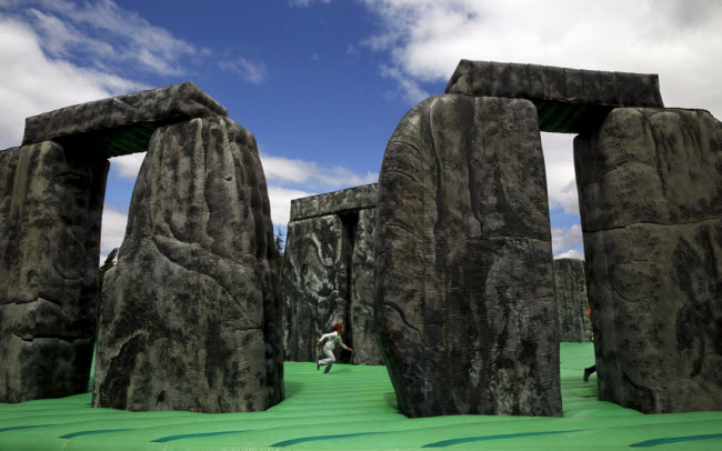 Bé gái chơi trên nệm hơi có hình giống kỳ quang Stonehenge trong một công viên ở Mostoles, Tây Ban Nha.