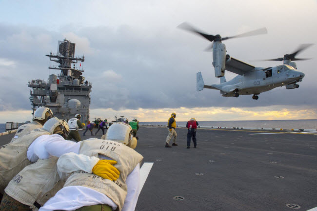 Các binh sĩ cố gắng đứng vững khi máy bay trực thăng MV-22 Osprey cất cánh khỏi tàu sân bay USS Bonhomme Richard.