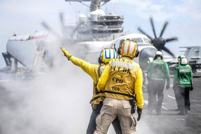 Binh sĩ ra hiệu cho máy bay vận tải C-2A Greyhound trên boong tàu sân bay USS Ronald Reagan.