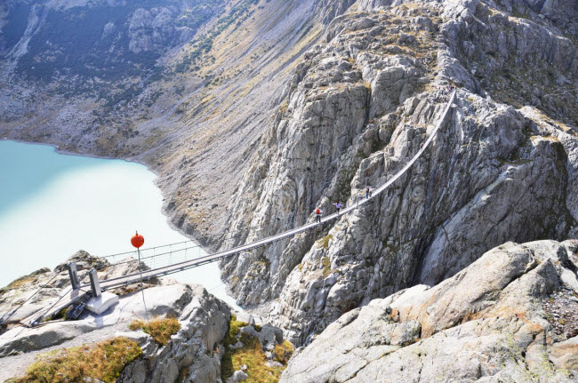 Chỉ những du khách dũng cảm mới dám đi qua cây cầu treo dài nhất thế giới Trift Bridge trên dãy núi Alps ở Thụy Sĩ.