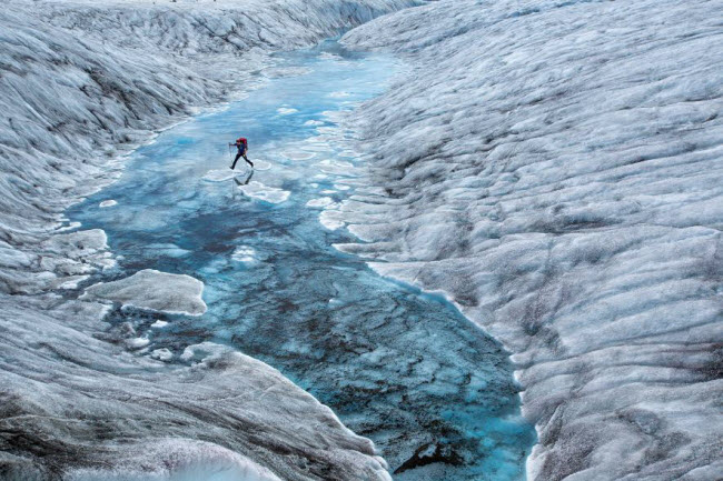 Một người đi bộ đường dài vượt qua hạ lưu sông băng Ruth ở Alaska. Địa hình ở đây rất gồ ghề bao gồm băng lở, hồ nước và các dòng suối. Ảnh: Aaron Huey