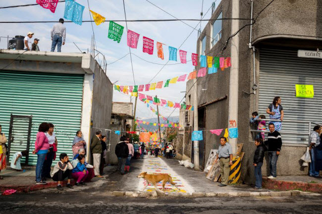 Chú chó đi qua ngõ nhỏ nhiều màu sắc tại khu Milpa Alta ở thành phố Mexico City. Milpa Alta là khu dân cư thích ăn uống nhất khi tổ chức tới 700 bữa tiệc mỗi năm, cho dù 1/2 số dân ở đây sống dưới mức nghèo. Ảnh: Carolyn Drake