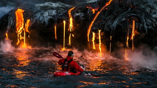 Chèo thuyền kayak gần dung nham nóng chảy ở Hawaii.