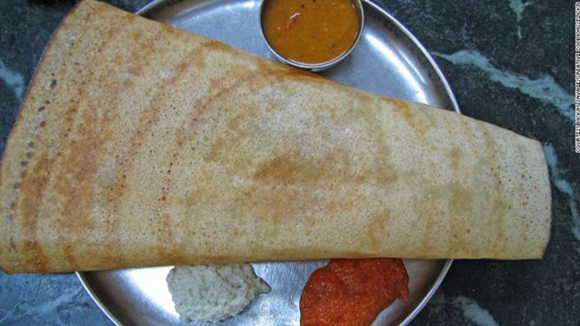 49. Masala dosa - Ấn Độ:

Một chiếc bánh bột gạo giòn tan, cuộn bên trong là khoai tây nghiền trộn sốt cay, sau đó chấm với nước sốt nấu từ cốt dừa, dưa muối, cà chua và đậu lăng cùng nhiều gia vị khác. Đây là món ăn sáng tuyệt vời, không chỉ ngon miệng mà còn giúp bạn no đến trưa.