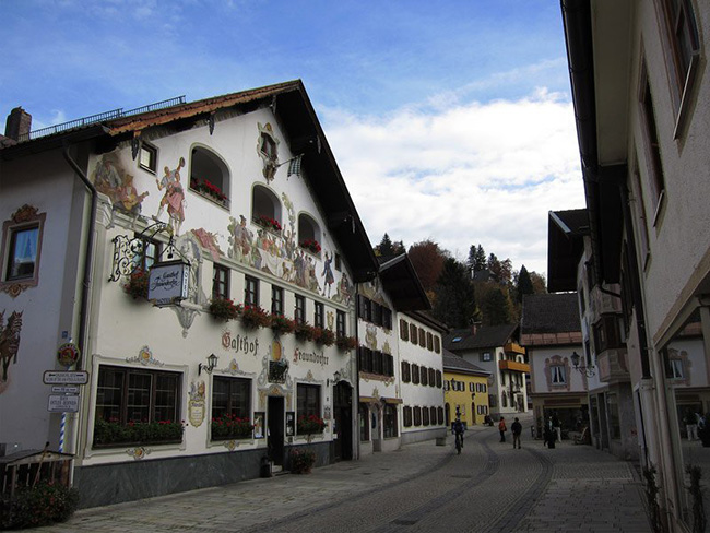 Garmisch-Partenkirchen, Bavaria, Đức: Garmisch-Partenkirchen là một thị trấn miền núi Bavarian rất mê hoặc du khách. chỉ cách Munich 80 phút đi xe lửa, thị trấn với những con phố hẹp, được bao bọc bởi các tòa nhà lịch sử thiết kế theo phong cách Bavarian Bavarian có ba hoặc bốn tầng, với những cánh chớp lật mở và mặt tiền được sơn màu phấn hồng và vẽ những hình ảnh sinh hoạt bình dị.