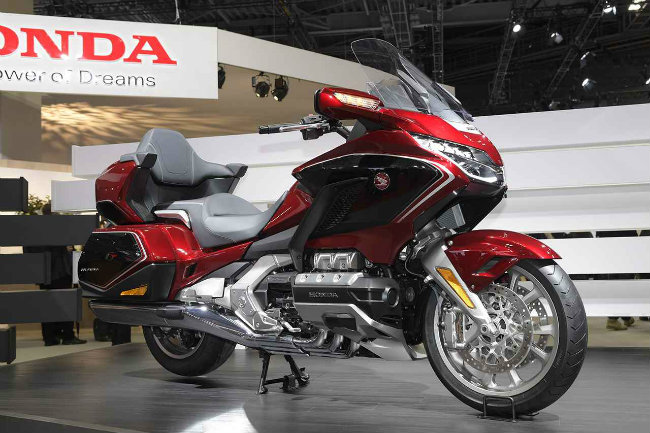 Lần này 2018 Honda Goldwing có hai phiên bản gồm phiên bản Goldwing tiêu chuẩn và Goldwing Tour. Cả hai đều có sẵn dạng hộp số sàn và hộp số lai DCT. Riêng Goldwing Tour còn có trang bị tùy chọn túi khí. Ảnh 2018 Goldwing Tour màu đỏ trang bị hộp số DCT.