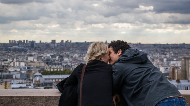 Cặp du khách hôn nhau khi ngắm cảnh từ bên ngoài Vương cung thánh đường Sacré-Cœur, Paris, Pháp.