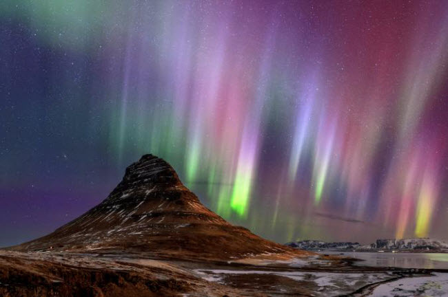 Ánh sáng bắc cực quang huyền ảo làm nền cho ngọn núi Kirkjufell trên bán đảo Snæfellsnes, Iceland.