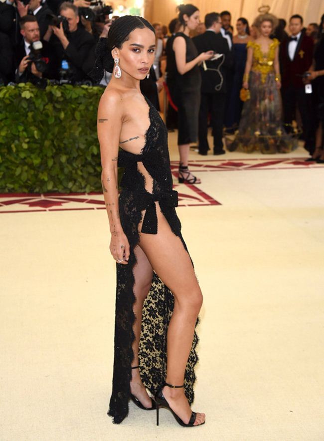 Zoe Kravitz từng gây ấn tượng với mẫu váy ren xuyên thấu táo bạo tại sự kiện&nbsp;Met Gala 2018. Bộ cánh cũng có phom dáng tương tự với thiết kế của Jenifer Lopez, nhưng chi tiết thắt nơ giúp người mặc kín đáo hơn.&nbsp;