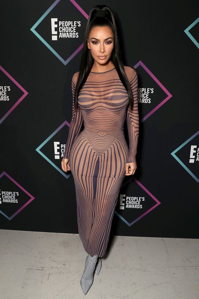 Chiếc váy ôm sát của Kim Kardashian mang đến hiệu ứng&nbsp;thị giác với những đường vân uốn lượn. Chi tiết in trên trang phục giúp người đẹp tôn lên vòng 1 gợi cảm, vòng 2 thon gọn và kéo dài đôi chân một cách tinh tế. Tuy nhiên, đôi boots cao cổ lại phá hỏng hoàn toàn hình ảnh của người đẹp.&nbsp;