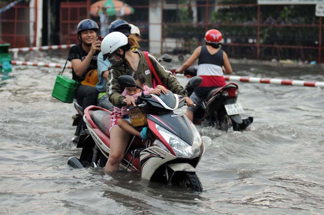 Phụ huynh mệt mỏi khi đi qua khu vực ngập nước trên đường Phan Anh