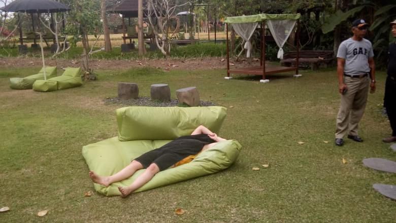 Cảnh sát Indonesia dùng khăn tắm che cho nữ du khách khỏa thân. Ảnh: Detik News