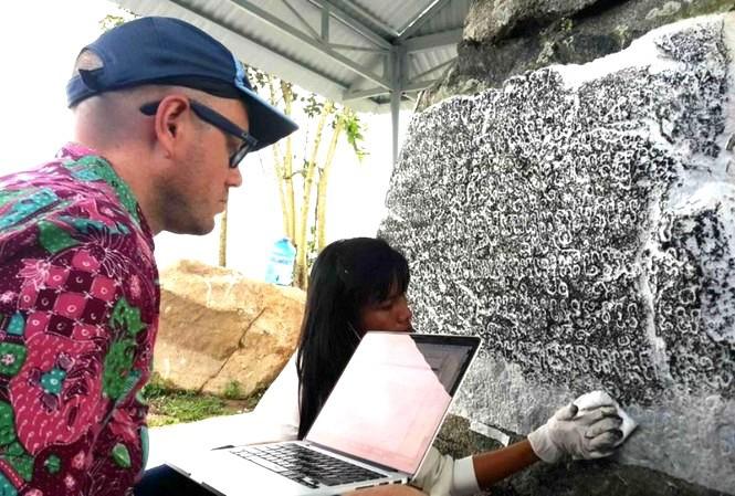Giáo sư Arlo Griffiths nghiên cứu dòng chữ khắc trên bia đá Chăm Pa. Ảnh Nguyễn Quang Tuệ&nbsp;