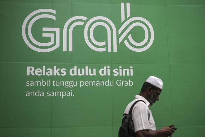 Một người đàn ông đi ngang qua pano quảng cáo của Grab tại Masjid Jamek ngày 27-3-2018.