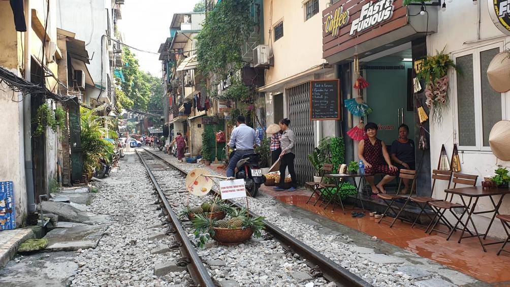 Người bán hàng rong bày cả quang gánh hoa quả để bán trong lòng đường sắt